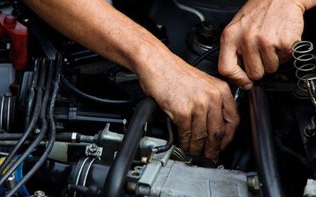 Arbeiten am geöffneten Motorraum eines Fahrzeugs
