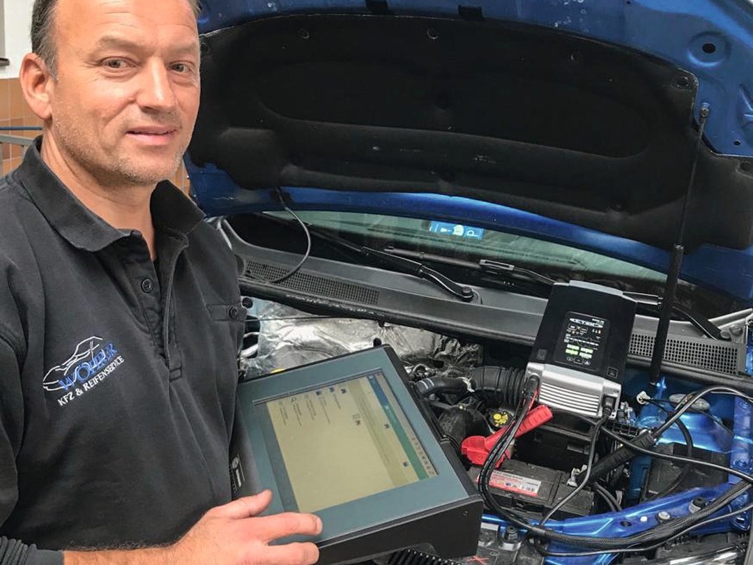 Hans Wöhrer mit Diagnosegerät am geöffneten Motorraum